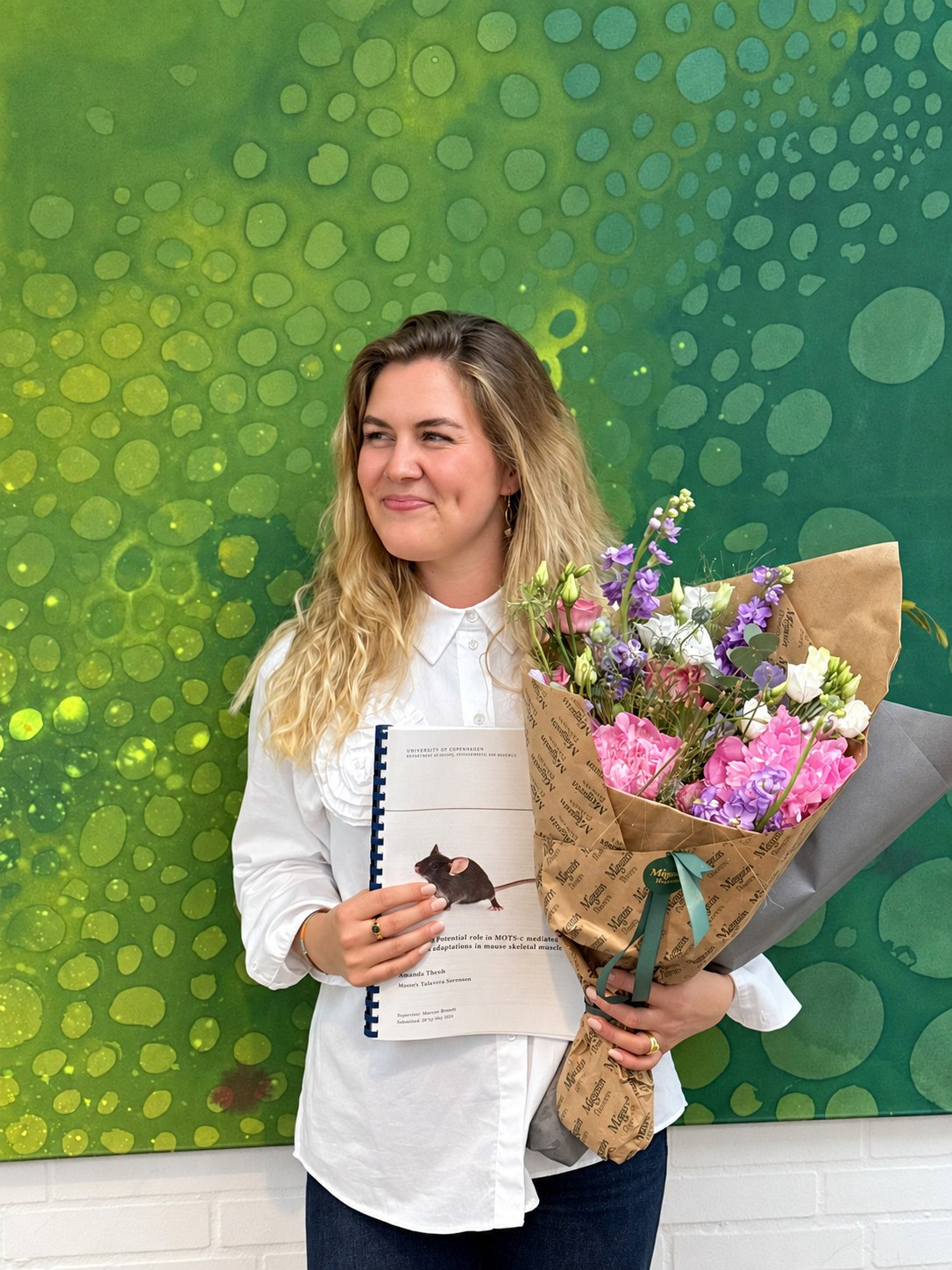 Amanda Takamiya Kristoffersen holding her MSc thesis in Cell Biology and Physiology, University of Copenhagen