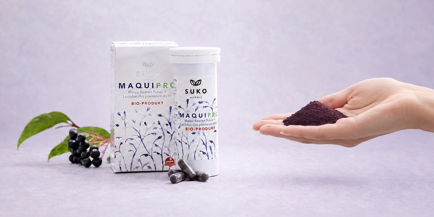 MaquiPro® box, tube and vegetarian capsules with fresh maqui berries and a hand holding freeze-dried maqui berry powder
