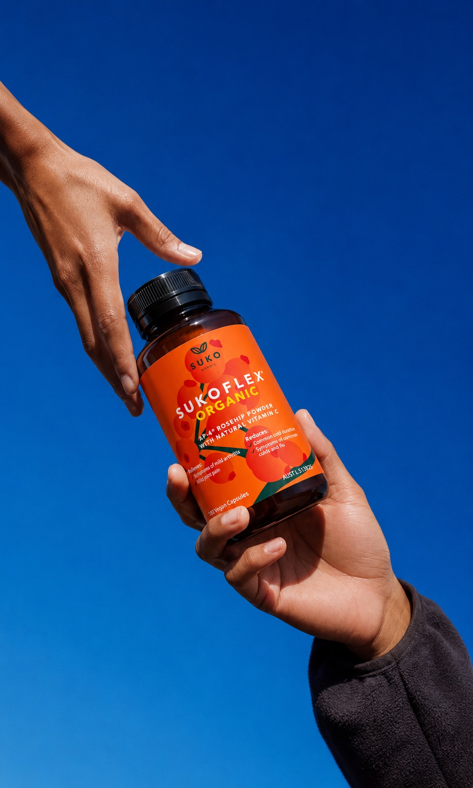 A bottle of SUKOFLEX® Organic AP-4® rosehip powder capsules being handed from one person to another, reflecting SUKO Nordic Australia's retail and wholesale partnerships