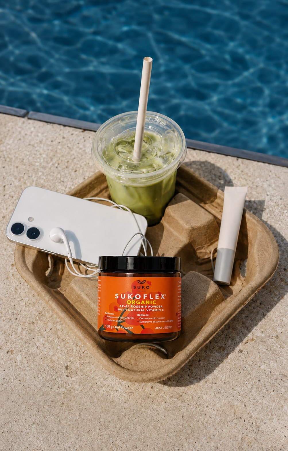 SUKOFLEX Organic rosehip powder beside a poolside iced matcha drink, phone and skincare tube